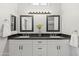 Modern bathroom with double sinks, black marble countertops, white cabinets, and sleek black hardware at 1932 S Arroyo Ln, Gilbert, AZ 85295