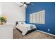 Bedroom featuring a high ceiling, ceiling fan, shuttered window, and blue accent wall at 1932 S Arroyo Ln, Gilbert, AZ 85295
