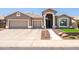 Charming single-story home featuring a well-manicured front yard, tile roof, and a three-car garage at 1932 S Arroyo Ln, Gilbert, AZ 85295