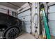 A garage view showing a black car being charged, ladders and garage door openers on a neutral wall at 1932 S Arroyo Ln, Gilbert, AZ 85295