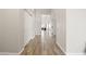 Bright hallway with wood-look floors, white walls, and multiple doorways leading to various rooms at 1932 S Arroyo Ln, Gilbert, AZ 85295