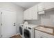 Laundry room with modern washer and dryer, sink, and white cabinets for storage at 1932 S Arroyo Ln, Gilbert, AZ 85295