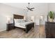Primary bedroom boasts wood-look tile floors, a ceiling fan, and an ensuite bathroom at 1932 S Arroyo Ln, Gilbert, AZ 85295