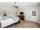 Spacious main bedroom features wood-look floors, ceiling fan, and access to en-suite bathroom and walk-in closet at 1932 S Arroyo Ln, Gilbert, AZ 85295