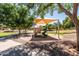 A shaded playground offers a safe space for , featuring slides, climbing structures, and soft ground at 1932 S Arroyo Ln, Gilbert, AZ 85295