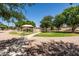 Community playground area with a covered play structure, grassy area, and walking path for outdoor enjoyment at 1932 S Arroyo Ln, Gilbert, AZ 85295