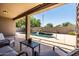 Relaxing covered patio provides a view of the pool, surrounded by lush greenery at 1932 S Arroyo Ln, Gilbert, AZ 85295