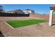 Landscaped backyard with green turf, rock ground cover, and block wall fencing at 19889 W Annika Dr, Litchfield Park, AZ 85340
