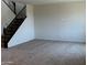 Large living room area with neutral carpet and staircase with dark wood banister at 19889 W Annika Dr, Litchfield Park, AZ 85340