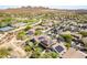 Expansive aerial view of a desert community with lush landscaping, pools, tennis courts, and beautiful mountain views at 2210 W Calle Del Sol --, Phoenix, AZ 85085