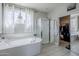 A primary bathroom with a garden tub, glass-enclosed shower, and tiled floors and walls at 2210 W Calle Del Sol --, Phoenix, AZ 85085