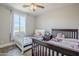 Cozy bedroom featuring two beds, a ceiling fan, and a bright window with natural light at 2210 W Calle Del Sol --, Phoenix, AZ 85085