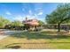 Exterior of the community clubhouse featuring desert landscaping, mature trees, and walking paths at 2210 W Calle Del Sol --, Phoenix, AZ 85085