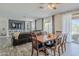 Open-concept living and dining area with hardwood floors and a large leather sectional sofa at 2210 W Calle Del Sol --, Phoenix, AZ 85085