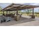 Outdoor pavilion area with seating, stone pillars, and a built-in grill, perfect for gatherings at 2210 W Calle Del Sol --, Phoenix, AZ 85085