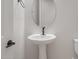 Charming powder room with pedestal sink, oval mirror, and modern matte-black hardware at 22528 E San Tan Blvd, Queen Creek, AZ 85142