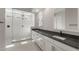 A modern bathroom features a glass-enclosed shower, double sinks, and black fixtures at 22528 E San Tan Blvd, Queen Creek, AZ 85142