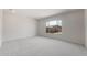 A bedroom features neutral-colored walls and carpet, and a large window at 22528 E San Tan Blvd, Queen Creek, AZ 85142
