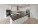 A modern kitchen features white cabinets, stainless steel appliances, an island, and stylish finishes at 22528 E San Tan Blvd, Queen Creek, AZ 85142