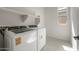 Convenient laundry room with modern washer, dryer, storage shelves, and a window for natural light at 22528 E San Tan Blvd, Queen Creek, AZ 85142