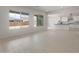 Open-concept living area featuring large windows, neutral paint, light tile flooring, and a kitchen area at 22528 E San Tan Blvd, Queen Creek, AZ 85142