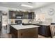 Stylish kitchen with dark cabinets, marble countertops, and a functional center island at 22783 W Cantilever St, Buckeye, AZ 85326