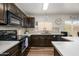 Well-lit kitchen featuring dark cabinets, white countertops and backsplash, and modern appliances at 22783 W Cantilever St, Buckeye, AZ 85326