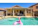 Beautiful backyard pool with patio area and outdoor dining, featuring a pink flamingo floatie at 22783 W Cantilever St, Buckeye, AZ 85326