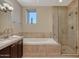Bathroom featuring a luxurious soaking tub and a glass-enclosed shower at 2402 E Esplanade Ln # 1101, Phoenix, AZ 85016
