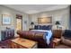 Elegant bedroom featuring a leather bed frame, side tables, and decoratively displayed art at 2402 E Esplanade Ln # 1101, Phoenix, AZ 85016