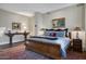 Bedroom with a wood-framed bed, ornate rug, lamps, and decorative console table at 2402 E Esplanade Ln # 1101, Phoenix, AZ 85016