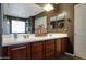 Bathroom with dual sinks, dark wood cabinets, and decorative lighting fixtures at 30185 W Flower St, Buckeye, AZ 85396