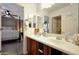 Clean bathroom with a double sink vanity, large mirror, and decorative floral shower curtain at 30185 W Flower St, Buckeye, AZ 85396