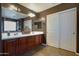 Bathroom featuring dual sinks, dark wood cabinets and sliding door closet at 30185 W Flower St, Buckeye, AZ 85396