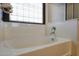 Bathroom features a soaking tub, tile flooring, and a bright window at 30185 W Flower St, Buckeye, AZ 85396