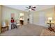 Spacious bedroom with a vanity leading to bathroom, a ceiling fan, and neutral color scheme at 30185 W Flower St, Buckeye, AZ 85396