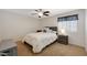 Comfortable bedroom with a queen bed, ceiling fan, and soft lighting at 30185 W Flower St, Buckeye, AZ 85396