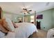 Bright bedroom featuring a large bed, ceiling fan, and an en-suite bathroom at 30185 W Flower St, Buckeye, AZ 85396