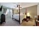 Serene bedroom with a four-poster bed, ceiling fan, and soft natural light from the windows at 30185 W Flower St, Buckeye, AZ 85396