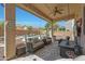 Well-appointed covered patio with outdoor furniture, overlooking the pool and backyard oasis at 30185 W Flower St, Buckeye, AZ 85396