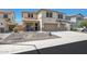 Two-story stucco home featuring a three-car garage, desert landscaping, and covered front porch at 30185 W Flower St, Buckeye, AZ 85396