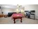 Inviting game room with a pool table, comfortable seating, and a dedicated workspace at 30185 W Flower St, Buckeye, AZ 85396