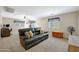 Spacious living room with a dark leather couch, neutral walls, and a ceiling fan at 30185 W Flower St, Buckeye, AZ 85396