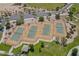 Aerial view of community tennis courts with green playing surface and parking in the distance at 30185 W Flower St, Buckeye, AZ 85396