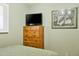 Bedroom featuring a wooden dresser, mounted TV, and shuttered windows at 3237 S Albert Ave, Tempe, AZ 85282