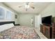 Bedroom with a ceiling fan, light green walls, and a bed with a colorful quilt at 3237 S Albert Ave, Tempe, AZ 85282
