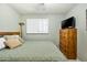 Bedroom features shutters, dresser, TV, and bed with green comforter for a cozy aesthetic at 3237 S Albert Ave, Tempe, AZ 85282
