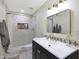 Bright bathroom featuring a tiled shower, dark vanity, and decorative mirror at 3441 N 31St St # 118, Phoenix, AZ 85016