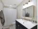 Bright bathroom featuring a tiled shower, dark vanity, and decorative mirror at 3441 N 31St St # 118, Phoenix, AZ 85016
