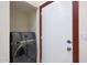 A laundry area features a gray washer/dryer and white door with red trim at 3441 N 31St St # 118, Phoenix, AZ 85016